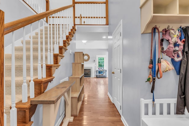 8369 Shadetree Ln, Ooltewah, TN 37363 - foyer entrance featuring wood-type flooring, a high ceiling, stairs, a fireplace, and baseboards