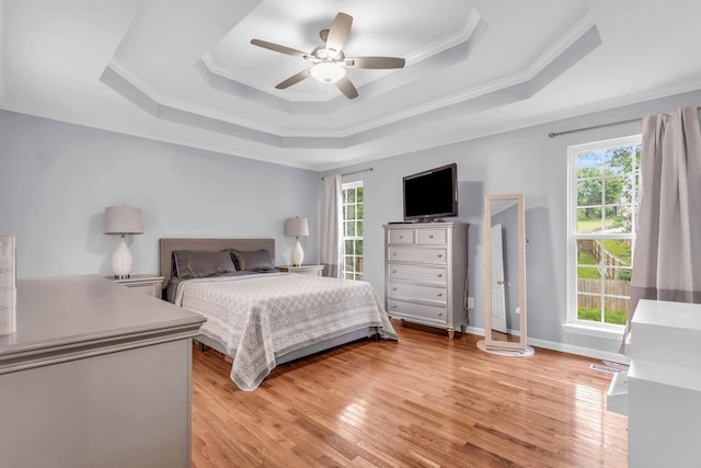 8369 Shadetree Ln, Ooltewah, TN 37363 - bedroom with a raised ceiling, multiple windows, ornamental molding, light wood finished floors, and a ceiling fan