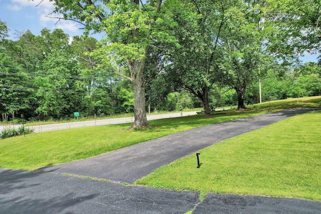 surrounding community featuring a lawn and asphalt driveway
