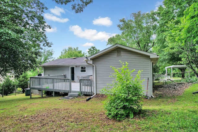 rear view of property with a yard and a deck