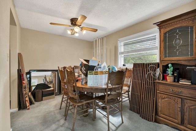 dining room with carpet floors, a ceiling fan, and a textured ceiling