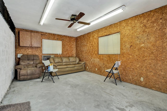 living room featuring ceiling fan and unfinished concrete floors
