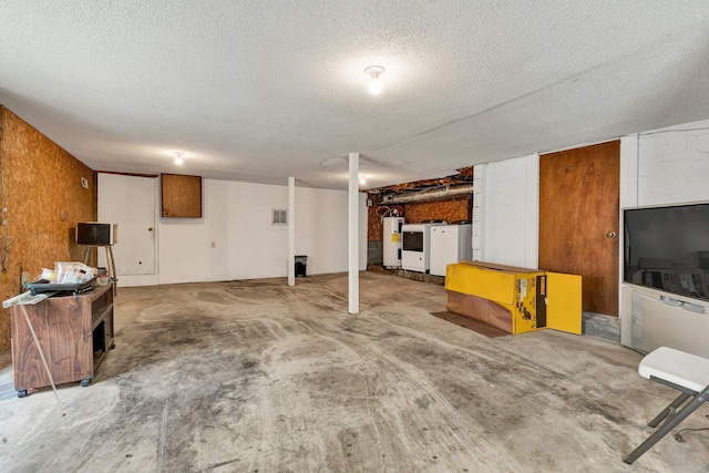 finished basement featuring electric water heater and a textured ceiling
