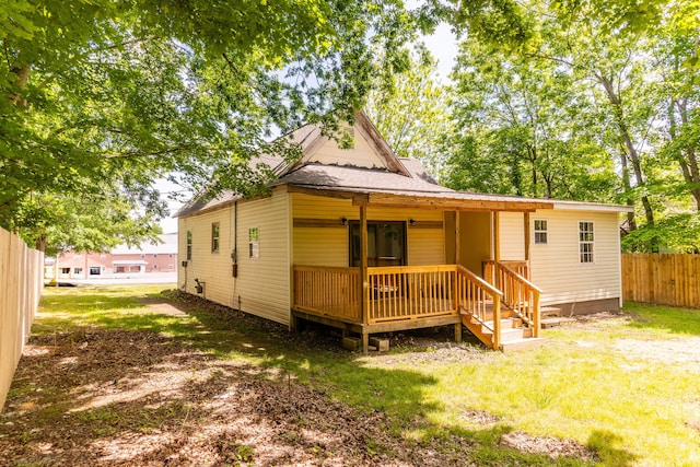 rear view of property featuring roof with shingles and a porch