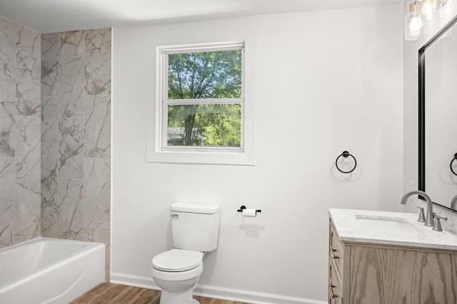 full bath with vanity, wood finished floors, a tub, toilet, and baseboards