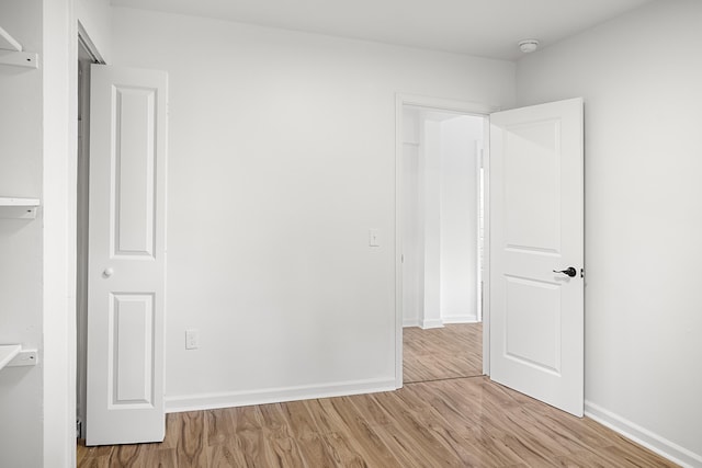 unfurnished bedroom with wood finished floors and baseboards