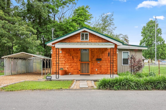 150 SE Fair St, Cleveland, TN 37311 - bungalow-style house featuring a detached carport, dirt driveway, metal roof, covered porch, and board and batten siding