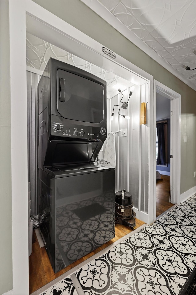 150 SE Fair St, Cleveland, TN 37311 - laundry room with stacked washing machine and dryer, wood finished floors, and baseboards