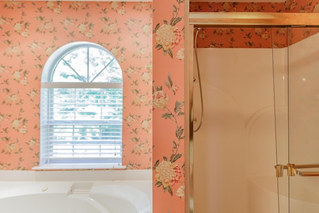 bathroom with wallpapered walls, a shower stall, and a garden tub