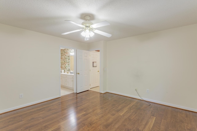 unfurnished room featuring wood finished floors, a ceiling fan, baseboards, and a textured ceiling