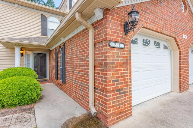 property entrance featuring brick siding and a garage