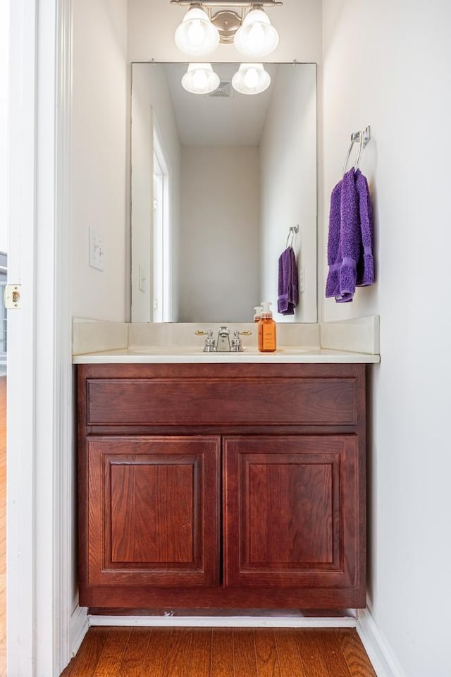 bathroom featuring vanity, baseboards, and wood finished floors