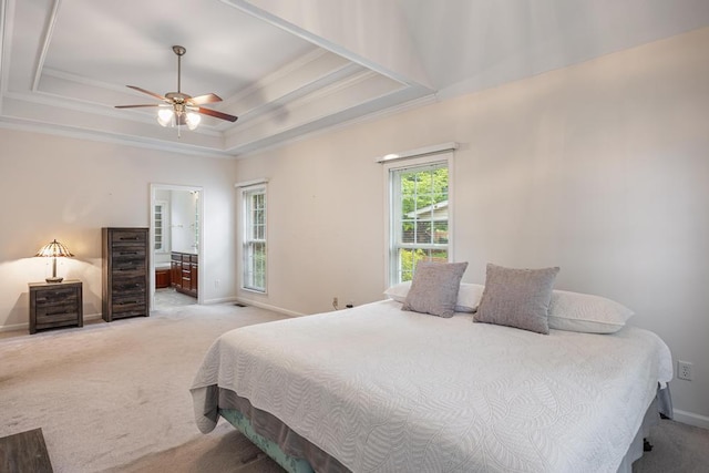 bedroom with ornamental molding, light colored carpet, baseboards, a raised ceiling, and connected bathroom