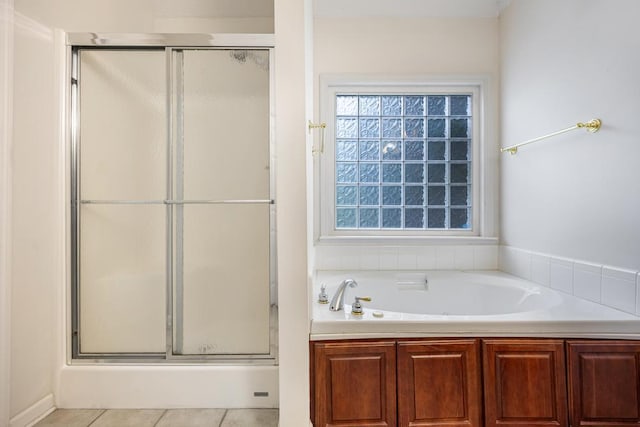 full bathroom featuring a shower stall, a garden tub, and tile patterned floors