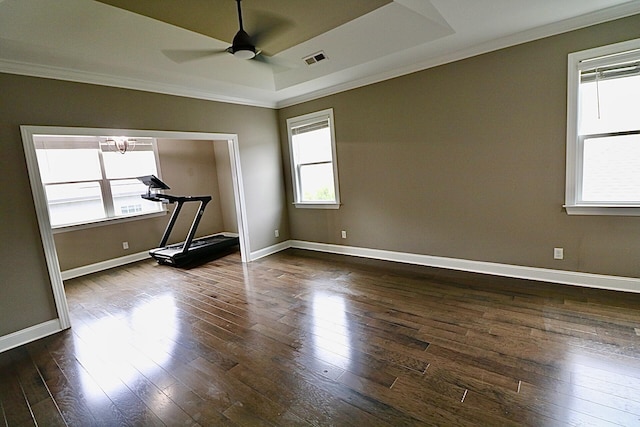 empty room featuring crown molding, dark wood-style floors, ceiling fan, baseboards, and a raised ceiling