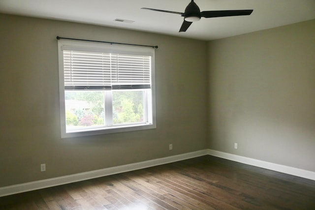 unfurnished room featuring dark wood-style floors, baseboards, and ceiling fan