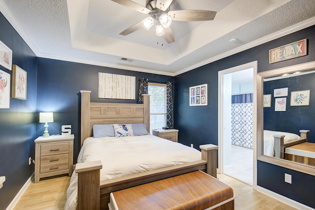 8820 Forest Pond Dr, Harrison, TN 37341 - bedroom featuring a tray ceiling, light wood-type flooring, baseboards, connected bathroom, and crown molding