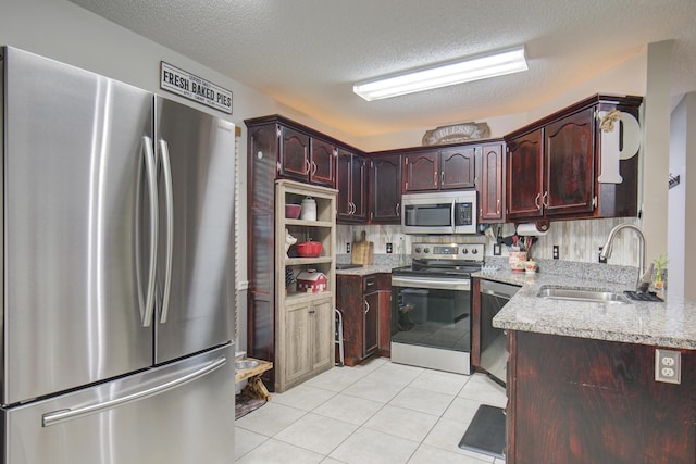 8820 Forest Pond Dr, Harrison, TN 37341 - kitchen with stainless steel appliances, a sink, light tile patterned flooring, light stone countertops, and a textured ceiling