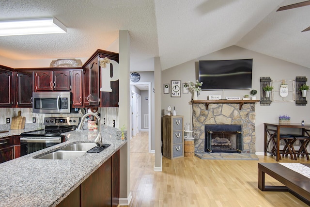 8820 Forest Pond Dr, Harrison, TN 37341 - kitchen with stainless steel appliances, reddish brown cabinets, a sink, light wood-style floors, and vaulted ceiling