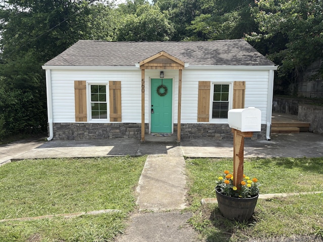 560 8th St NE, Cleveland, TN 37311 - bungalow with roof with shingles, stone siding, and a front lawn