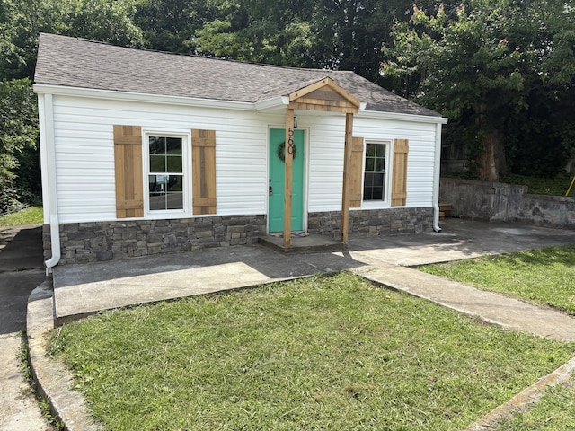 560 8th St NE, Cleveland, TN 37311 - bungalow featuring a shingled roof, stone siding, a front yard, and an outdoor structure