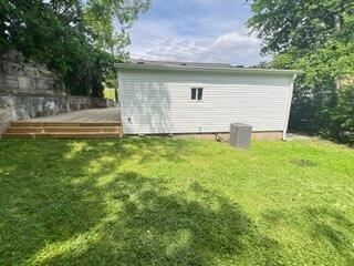 560 8th St NE, Cleveland, TN 37311 - rear view of property featuring a deck, a lawn, and central AC
