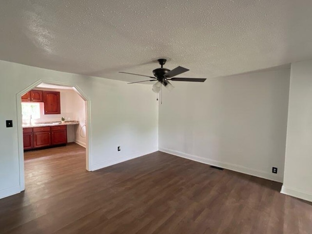 560 8th St NE, Cleveland, TN 37311 - spare room with dark wood-style floors, a ceiling fan, a textured ceiling, baseboards, and arched walkways