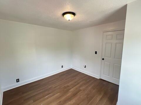 560 8th St NE, Cleveland, TN 37311 - empty room featuring dark wood-style flooring, baseboards, and a textured ceiling