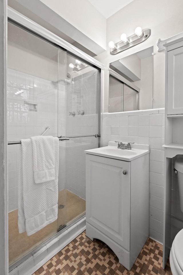 3703 Chula Vista Dr, Chattanooga, TN 37411 - bathroom with toilet, a shower stall, vanity, tile walls, and tile patterned floors