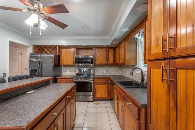 7429 Irongate Dr, Hixson, TN 37343 - kitchen featuring appliances with stainless steel finishes, a sink, dark countertops, brown cabinetry, and ornamental molding