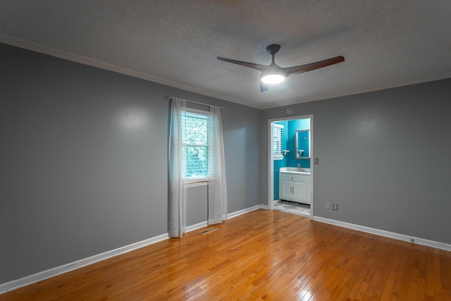 7429 Irongate Dr, Hixson, TN 37343 - empty room featuring a ceiling fan, a textured ceiling, light wood-style floors, crown molding, and baseboards