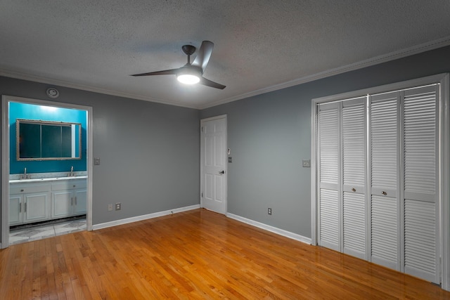 7429 Irongate Dr, Hixson, TN 37343 - unfurnished bedroom with a textured ceiling, ornamental molding, light wood-style floors, connected bathroom, and baseboards