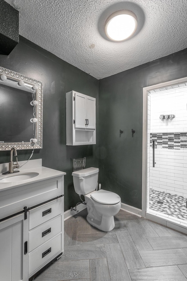 7429 Irongate Dr, Hixson, TN 37343 - full bathroom with toilet, a textured ceiling, a shower stall, baseboards, and vanity