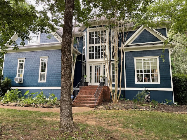 view of front of house featuring a front lawn and cooling unit