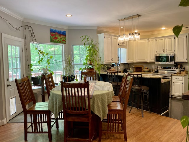 dining space with light wood-type flooring, crown molding, and recessed lighting