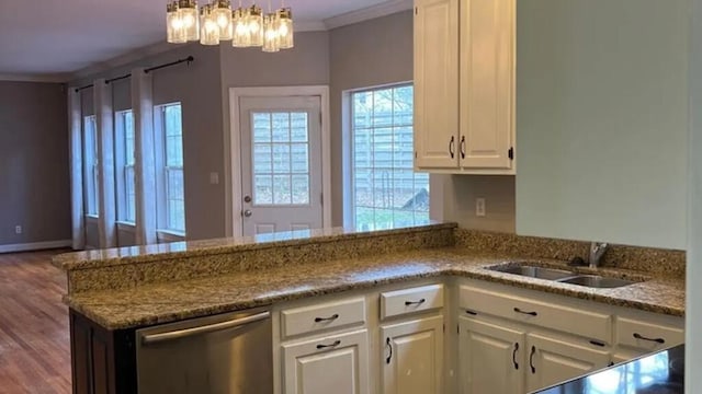 kitchen with stainless steel dishwasher, a sink, white cabinets, crown molding, and a chandelier