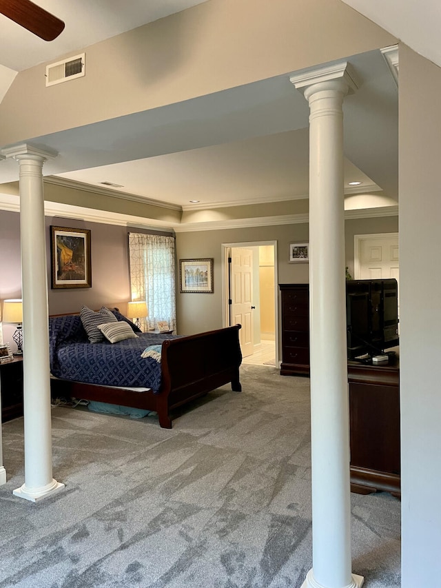 bedroom featuring decorative columns, carpet floors, a tray ceiling, and crown molding