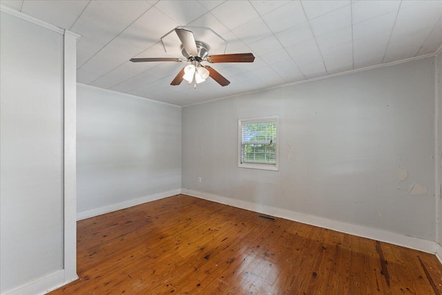 spare room with ornamental molding, a ceiling fan, hardwood / wood-style flooring, and baseboards