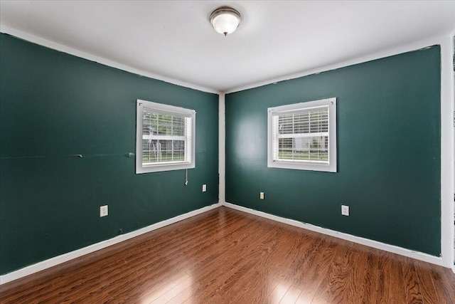 unfurnished room with wood finished floors and baseboards