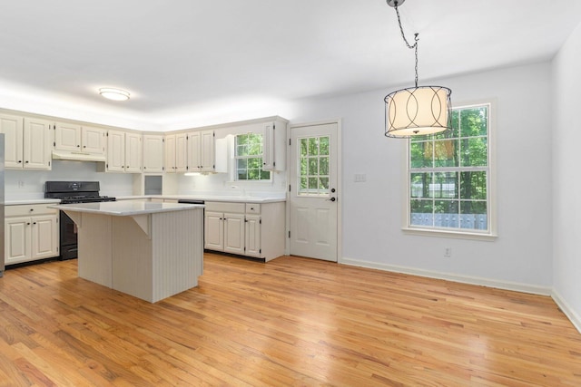 1623 Devlan Forest Ln, Signal Mountain, TN 37377 - kitchen with gas stove, light countertops, light wood-style flooring, a center island, and under cabinet range hood