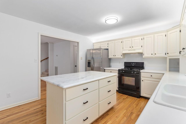 1623 Devlan Forest Ln, Signal Mountain, TN 37377 - kitchen with black range with gas stovetop, stainless steel refrigerator with ice dispenser, under cabinet range hood, light countertops, and light wood-style floors