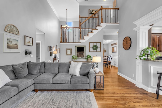 7983 Chianti Way, Chattanooga, TN 37421 - living room featuring a towering ceiling, ornamental molding, light wood-style floors, a chandelier, and stairway
