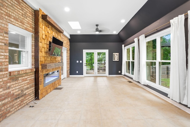 9416 Royal Mountain Dr, Chattanooga, TN 37421 - unfurnished living room with a skylight, a large fireplace, brick wall, light tile patterned floors, and ceiling fan