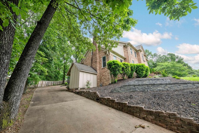 9416 Royal Mountain Dr, Chattanooga, TN 37421 - view of property exterior with brick siding, fence, driveway, an outbuilding, and a shed
