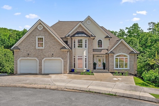 traditional-style house with an attached garage, brick siding, concrete driveway, and a shingled roof