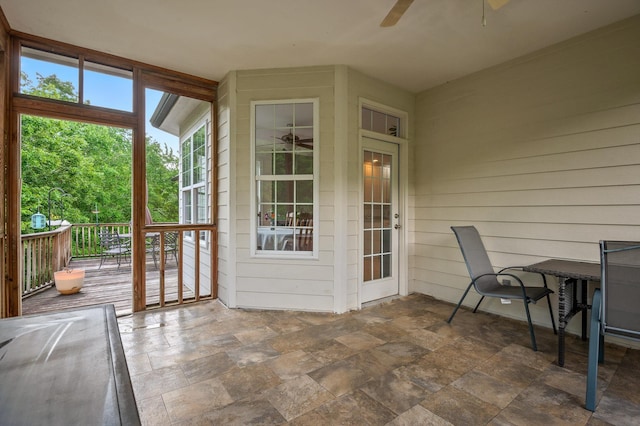 sunroom / solarium featuring a ceiling fan