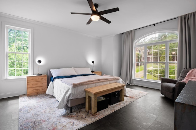 bedroom with multiple windows, ornamental molding, a ceiling fan, and baseboards