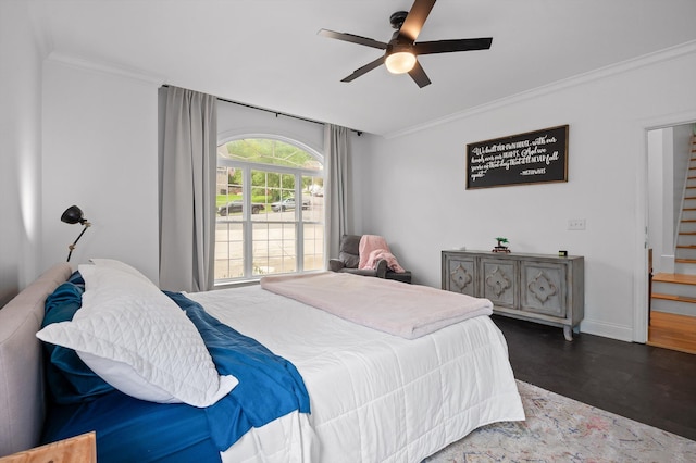 bedroom featuring crown molding, wood finished floors, baseboards, and ceiling fan