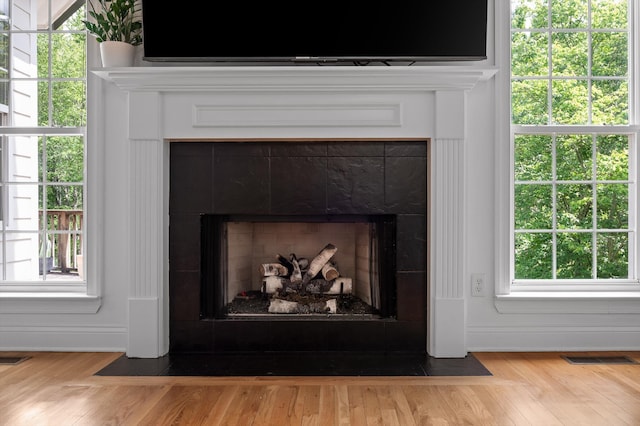 detailed view of a tiled fireplace and wood finished floors
