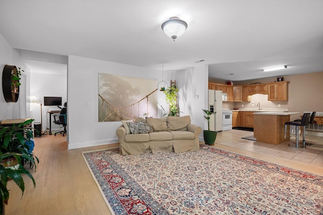 living area with baseboards and light wood-style flooring